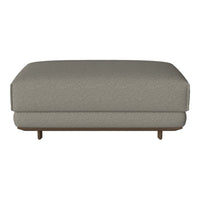 Gray upholstered ottoman with a subtle textured pattern and a stylish wooden base. Ideal for modern interiors.