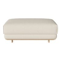 Cream-colored upholstered ottoman with a smooth texture and minimalist design, featuring light wooden legs.