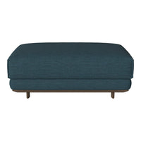 Dark teal upholstered ottoman with a sleek, minimalist design and wood legs. Ideal for modern decor.