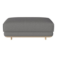 Gray upholstered ottoman with a subtle textured pattern and light wood legs. Perfect for modern living spaces.