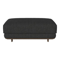 Dark gray upholstered ottoman featuring a subtle textured pattern and wooden legs. Stylish and modern design.