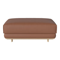 Brown leather ottoman with a smooth, minimalist design and light wooden legs, perfect for modern decor.