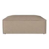 Beige square ottoman with a smooth, textured fabric finish. Simple, modern design complements various decor styles.