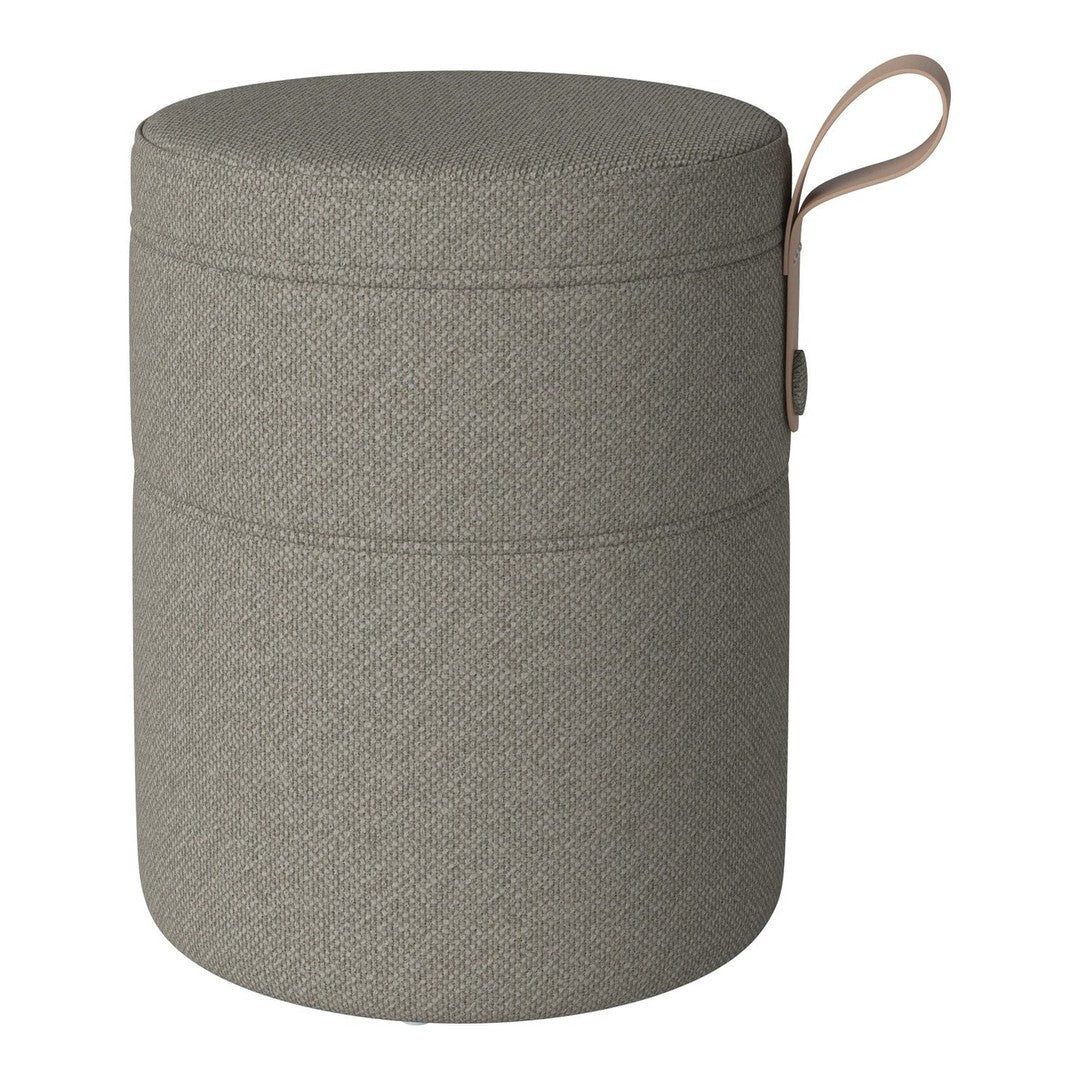 Round gray storage ottoman with a textured pattern and a leather pull handle. Perfect for stylish organization.