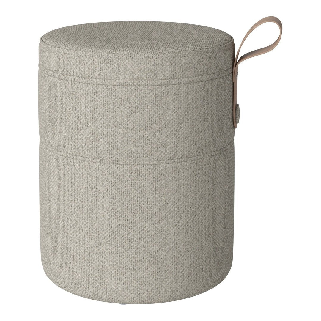Light gray cylindrical storage ottoman with a textured pattern and a tan leather handle.