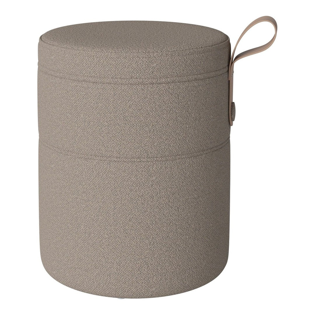 Round, textured storage container in muted beige with a simple, minimalist design and a convenient handle.