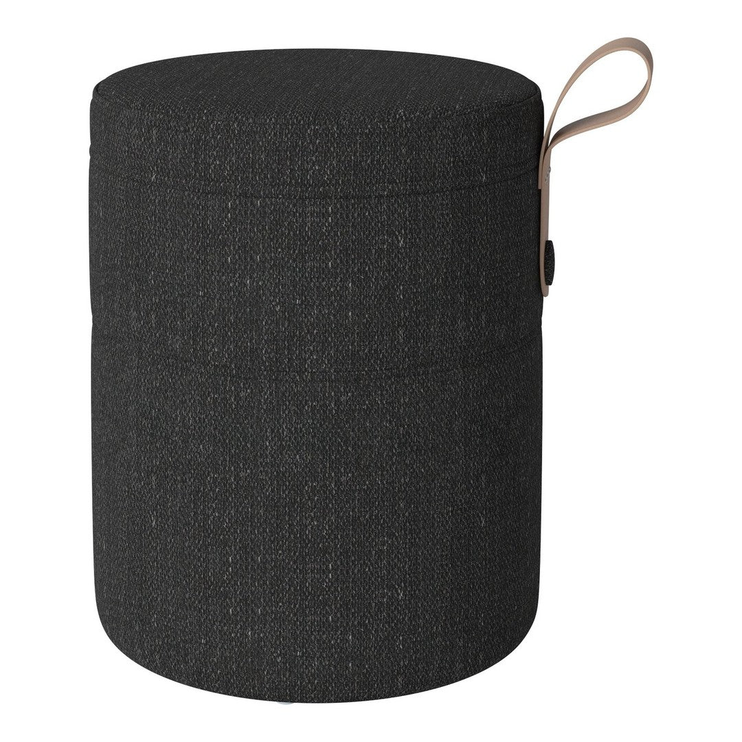 Round black storage ottoman featuring a textured fabric pattern with a tan leather handle.