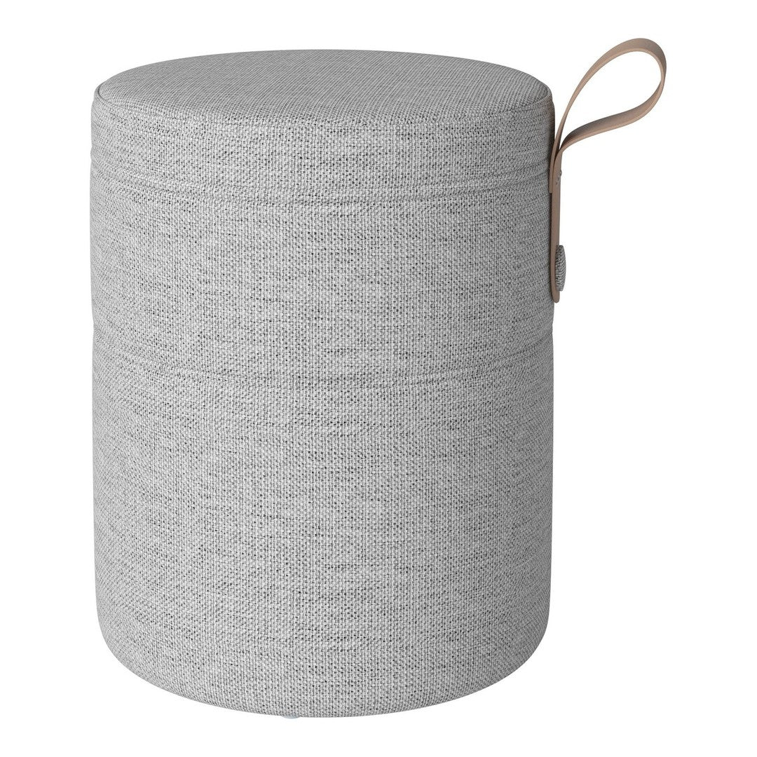 Gray cylindrical storage ottoman with a textured fabric pattern and a tan handle for easy carrying.