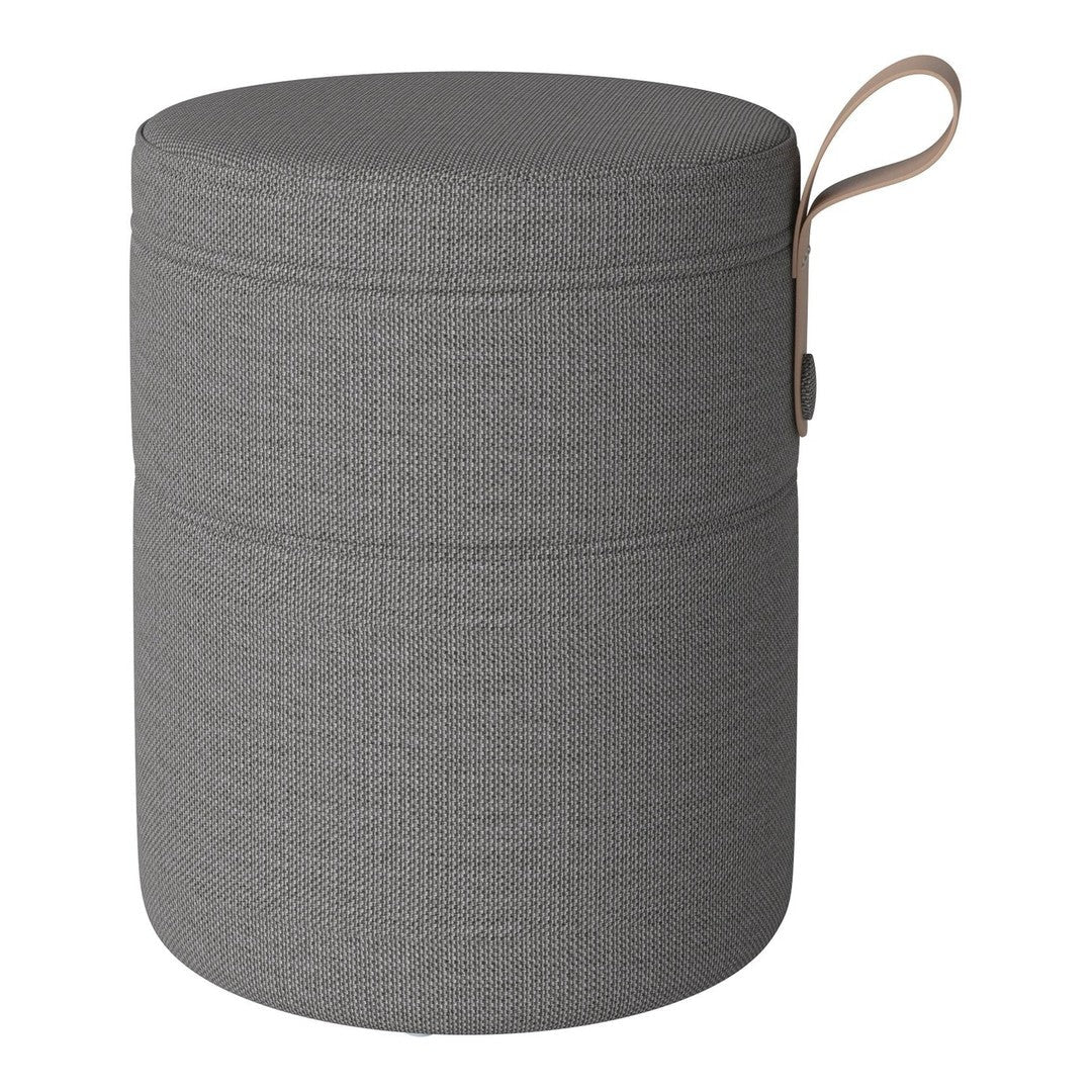 Gray round storage ottoman with a textured pattern and leather handle for easy carrying. Perfect for modern decor.