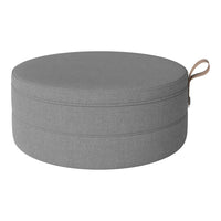 Round gray storage ottoman with a smooth texture and a stylish leather handle for easy carrying.