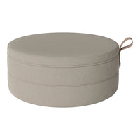 Round beige storage ottoman with simple, smooth texture and subtle stitching detail. Ideal for any decor.