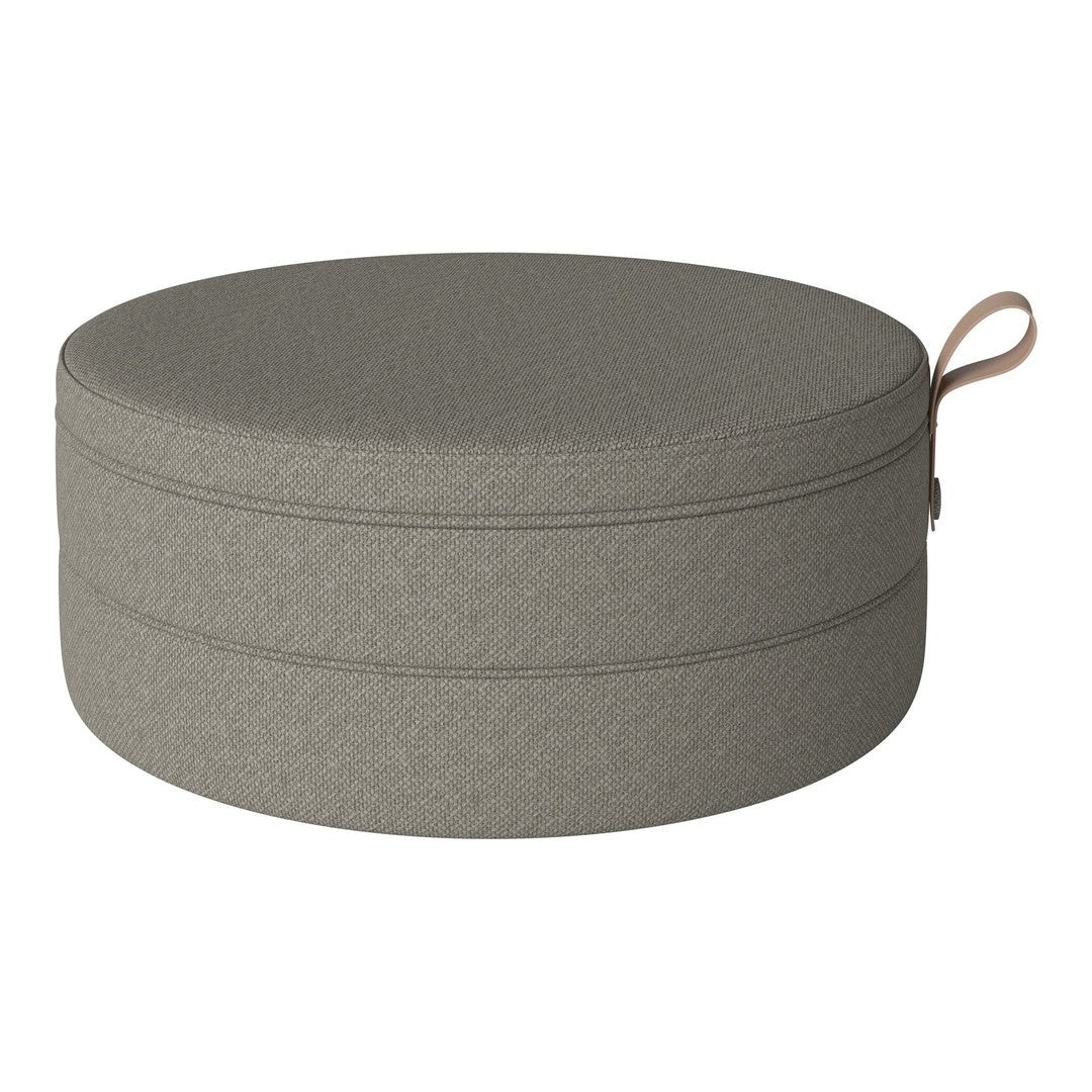 Round gray storage ottoman with a smooth texture and minimalistic design, featuring a stylish handle.