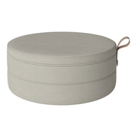 Round pouf in soft beige fabric with subtle stitching detail and a stylish leather handle. Ideal for modern decor.
