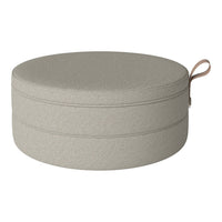 Light gray textured round pouf with a subtle stitched pattern and a convenient handle. Ideal for modern decor.