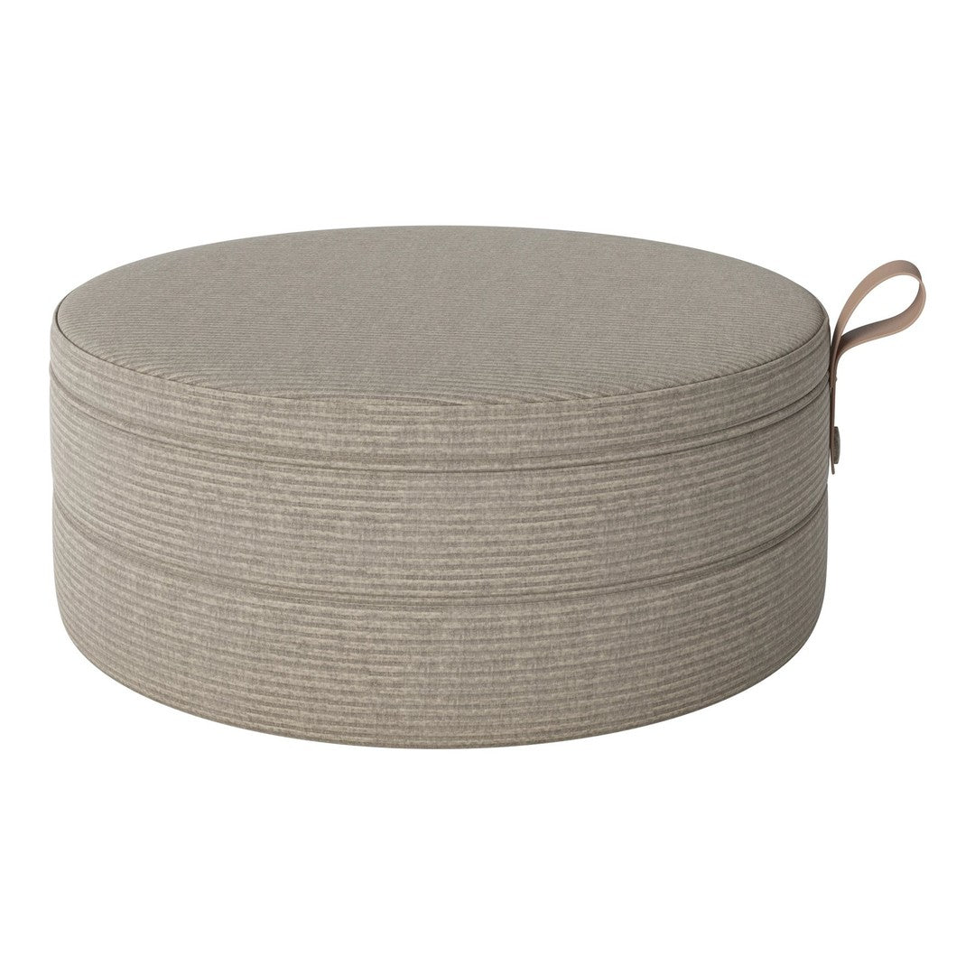 Round beige pouf with subtle textured stripes and a practical handle. Perfect for stylish home decor.