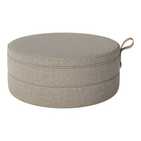 Round beige pouf with subtle textured stripes and a practical handle. Perfect for stylish home decor.