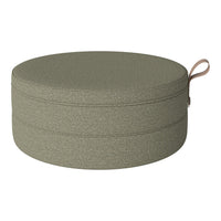 Round olive green pouf with a textured finish and a decorative handle. Perfect for modern decor.