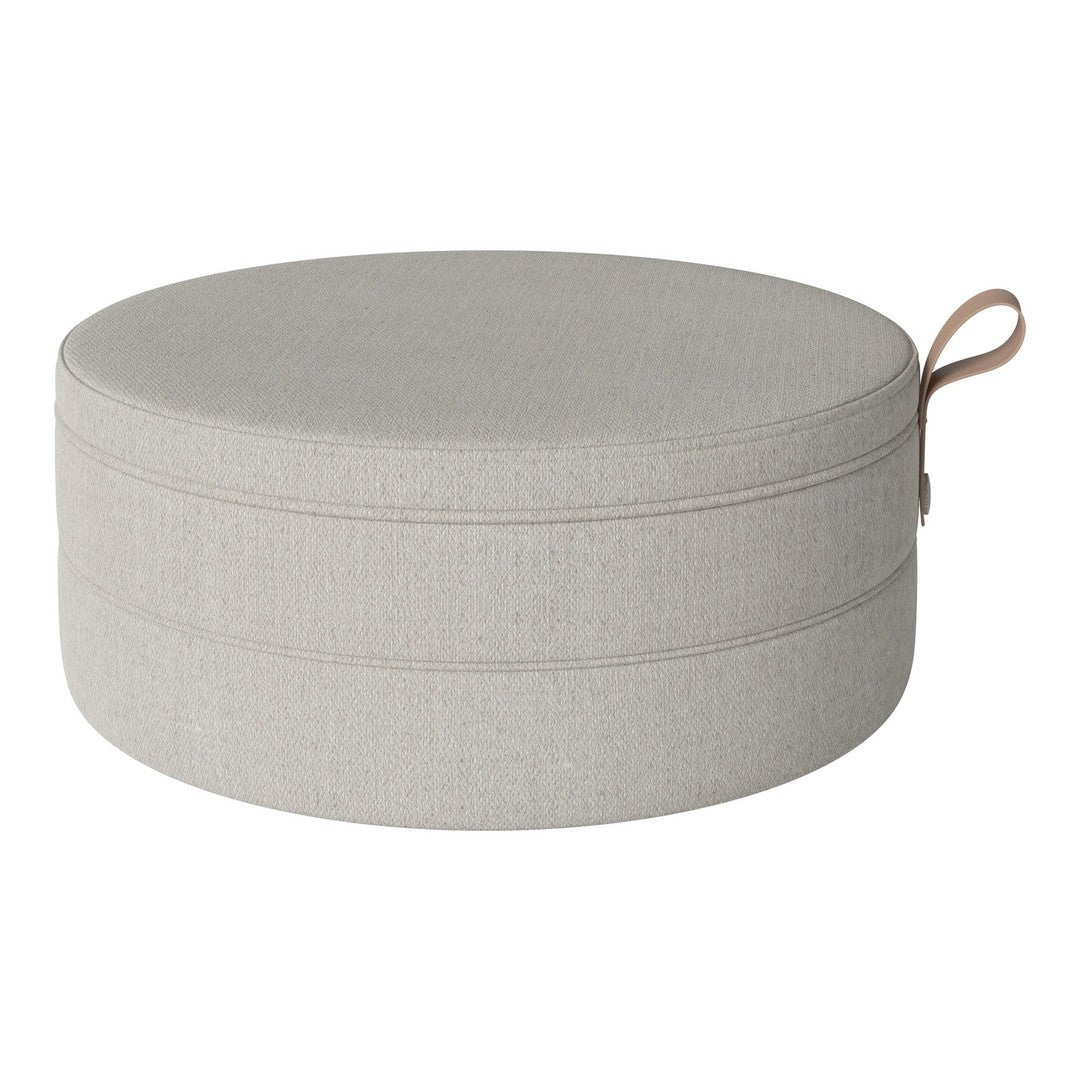 Light gray round pouf with a subtle textured pattern and practical carry handle.
