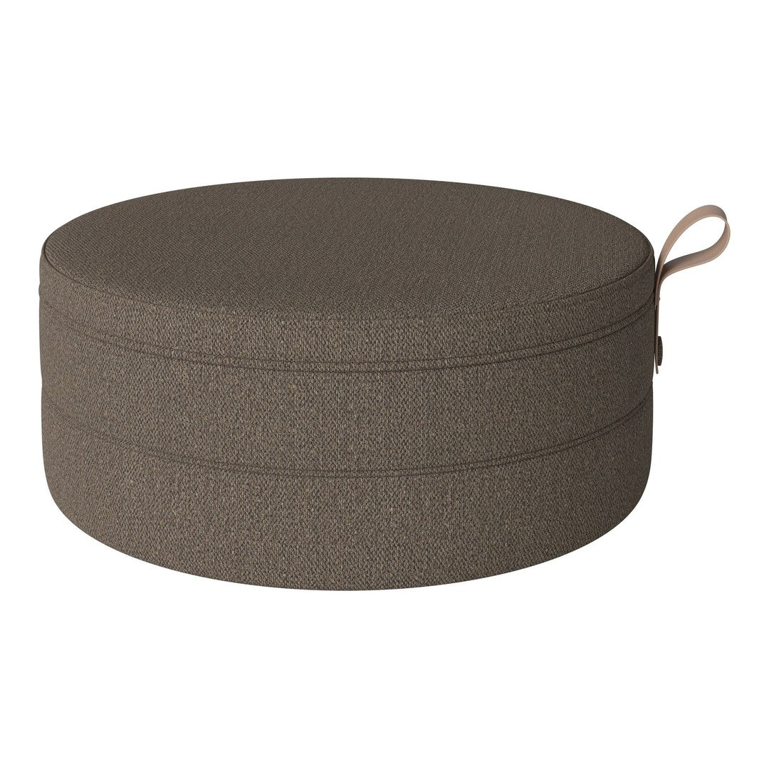Round brown pouf with a textured fabric finish and a convenient side handle. Ideal for modern decor.