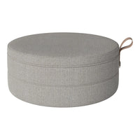 Gray round pouf with a smooth, textured fabric and a subtle seam pattern, featuring a stylish leather handle.