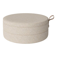 Round storage ottoman in soft beige fabric with subtle texture and a matching handle. Ideal for organizing stylishly.