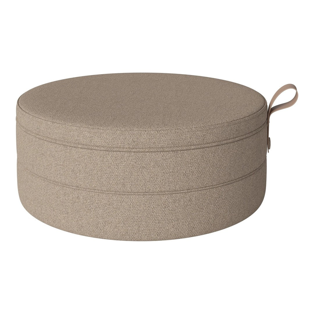 Round beige pouf with subtle texture and minimalist design, perfect for modern home decor.