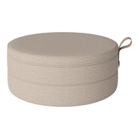 Round storage ottoman in soft beige fabric with a subtle textured pattern and convenient carry handle.
