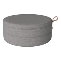 Round gray storage ottoman with a simple, textured fabric pattern and a convenient handle. Perfect for modern decor.