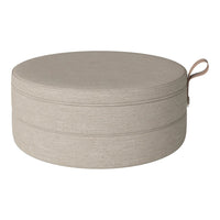 Round beige storage ottoman with a textured fabric finish and a convenient top handle.