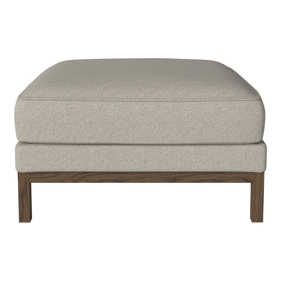 Light beige fabric ottoman with a subtle texture, featuring a dark wood frame for a modern touch.