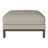 Light beige fabric ottoman with a subtle texture, featuring a dark wood frame for a modern touch.