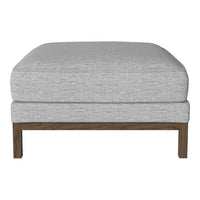 Light gray upholstered ottoman with a smooth fabric texture and a dark wood frame. Perfect for modern decor.
