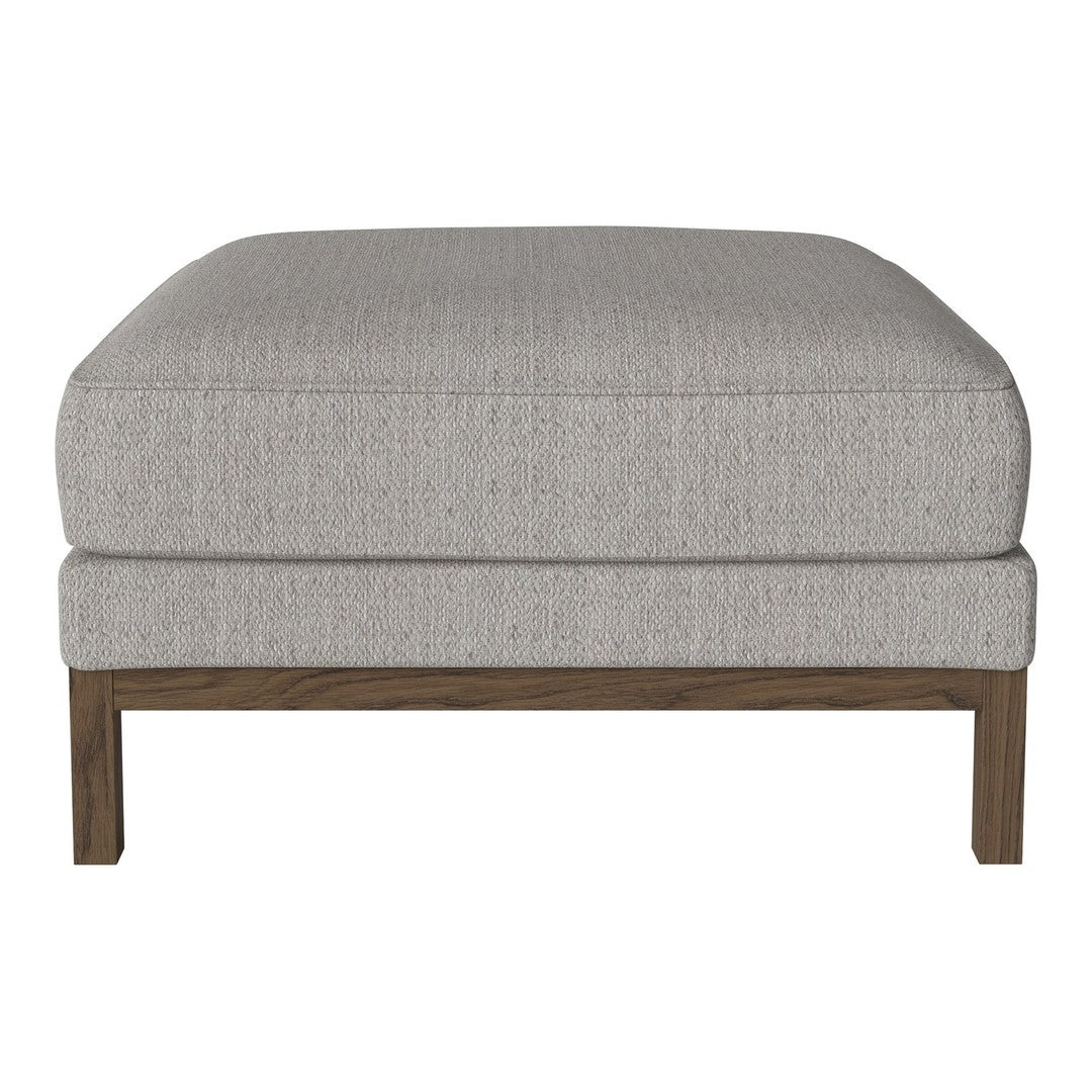 Gray upholstered ottoman with subtle textured pattern and wooden legs. Ideal for modern decor.