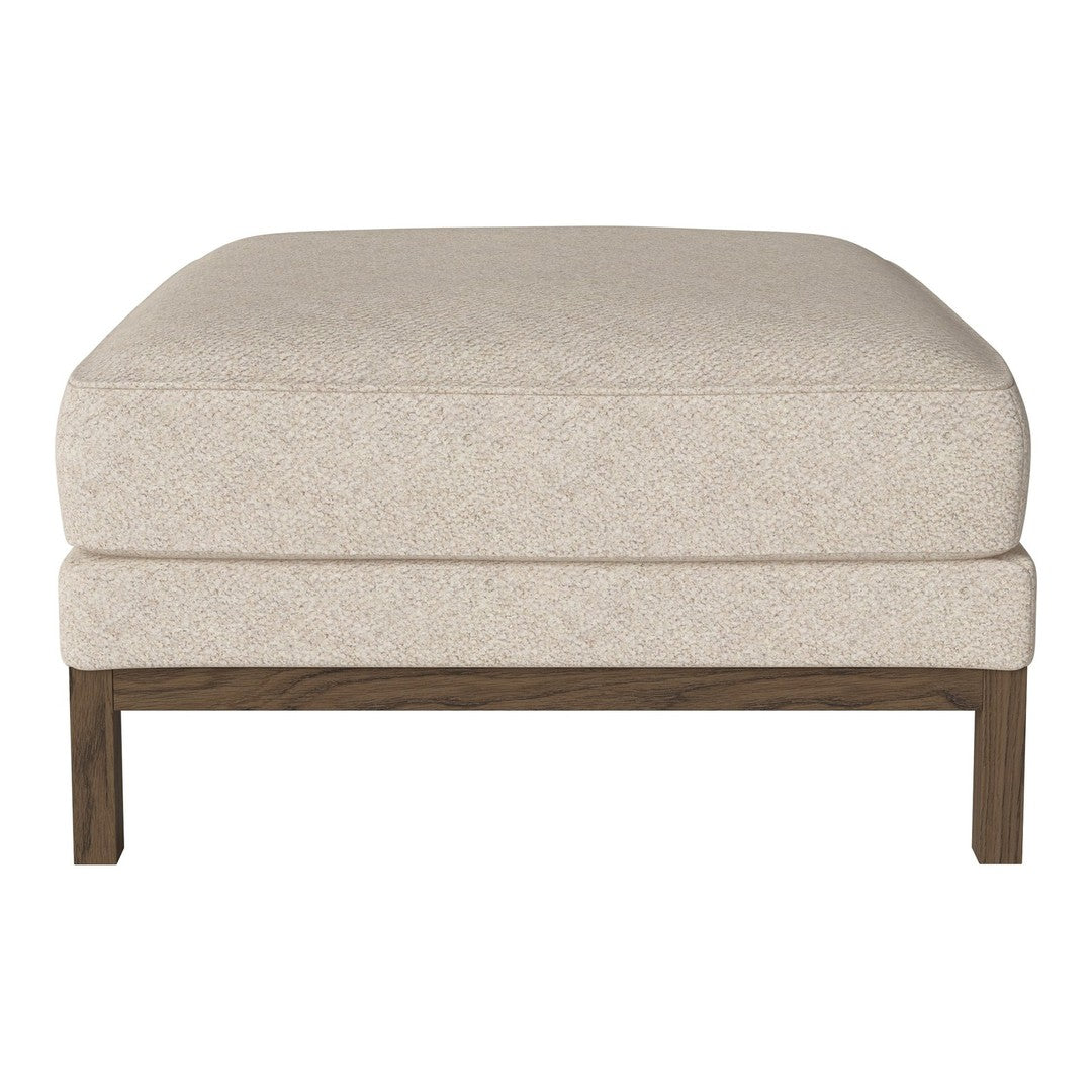 Cream-colored upholstered ottoman with a subtle textured pattern and solid wood legs.