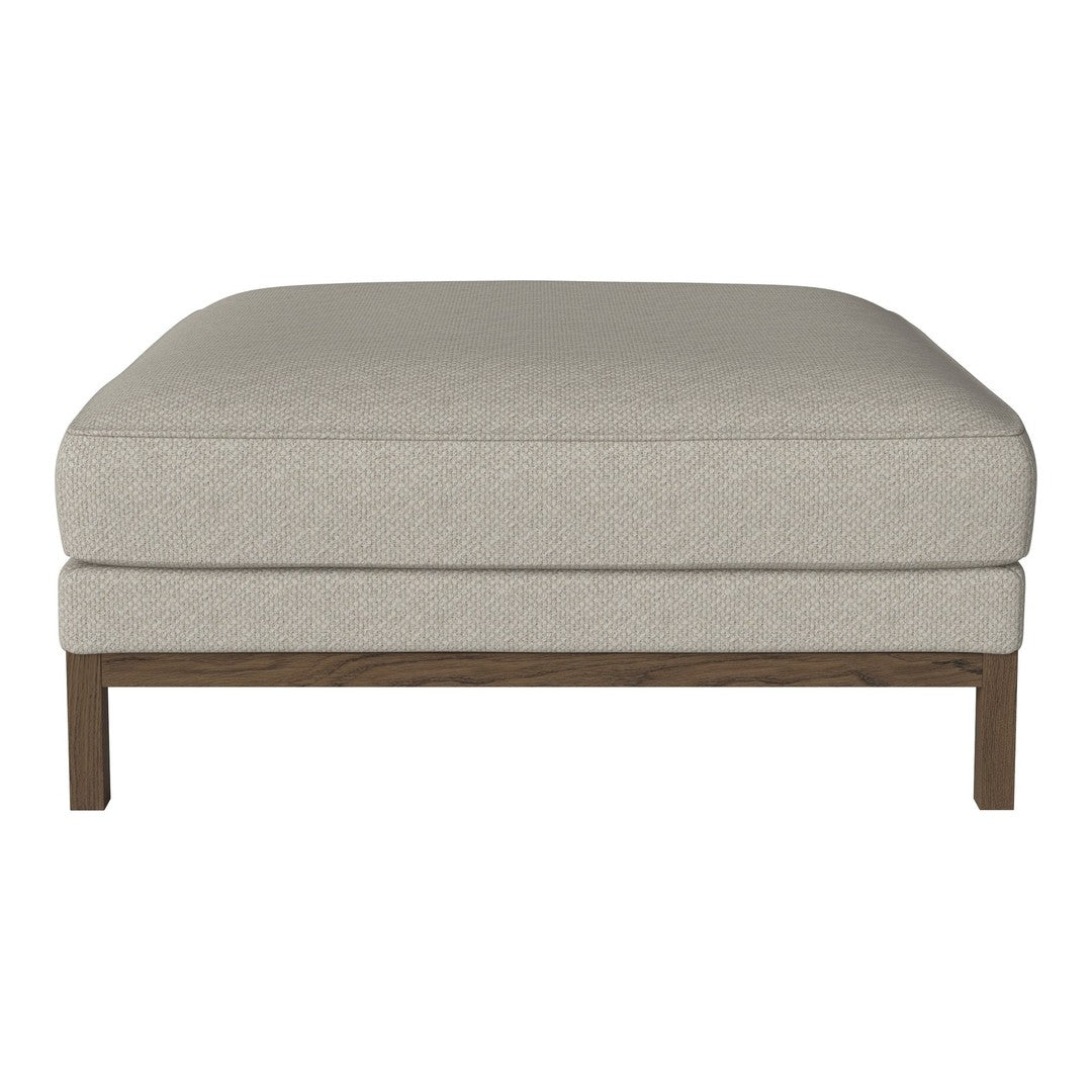Beige upholstered ottoman with a clean, solid design and wooden legs. Simple and modern accent for any decor.