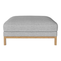 Gray upholstered ottoman with a smooth texture and light wooden legs, perfect for modern decor.