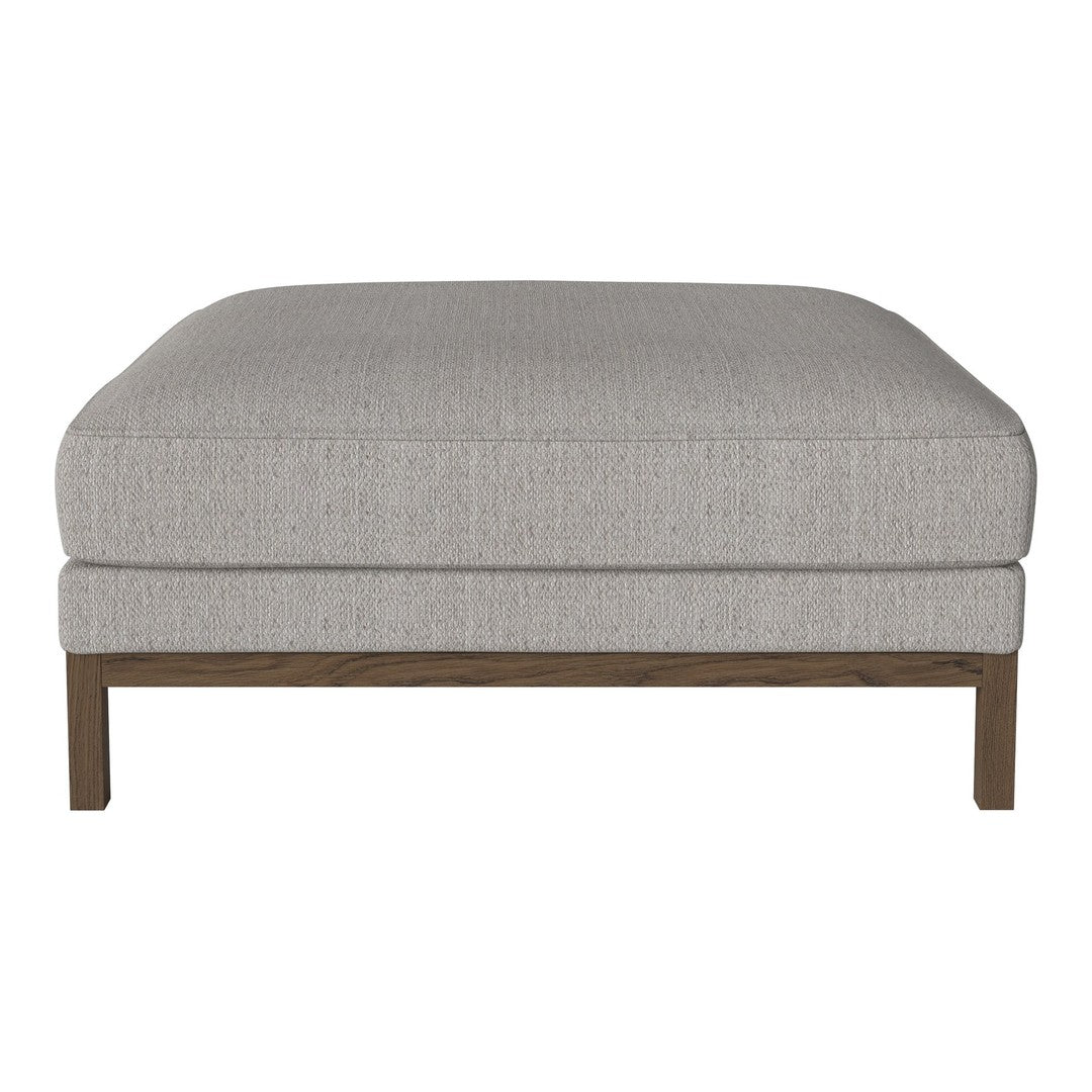 Neutral gray upholstered ottoman with a textured pattern and wooden legs. Ideal for modern living spaces.