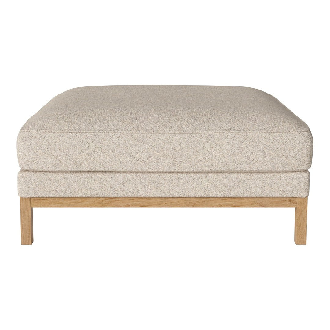 Beige upholstered ottoman with a smooth texture and light wood legs, perfect for modern decor.