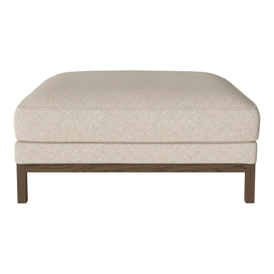 Beige upholstered ottoman with a textured finish and wooden legs, providing a neutral and versatile accent.
