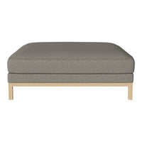 Gray upholstered ottoman with a smooth texture, featuring a minimalist wooden base. Ideal for modern interiors.