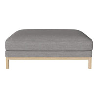 Gray upholstered ottoman with a plush cushion and light wooden legs, featuring a minimalist design.