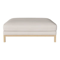 Neutral beige square ottoman with a smooth, solid surface and light wood legs, perfect for modern decor.
