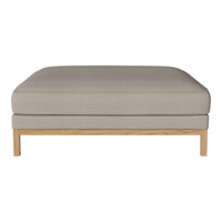 Neutral beige cushion with a smooth texture and light wooden legs, perfect for modern decor.