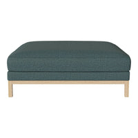 Teal patterned ottoman with a light wood base, featuring a minimalist design for modern decor.