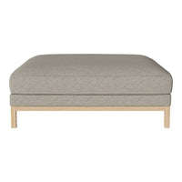 Light grey ottoman with a smooth, textured fabric and minimalist natural wood base. Perfect for modern decor.