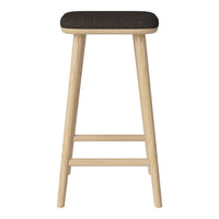 Black upholstered stool with natural wood legs, featuring a minimalist design and clean lines. Ideal for modern decor.