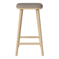 Light wood bar stool with a soft, gray upholstered seat, featuring a minimalistic and modern design.