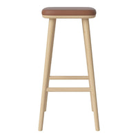Light wood bar stool with a tan leather seat, featuring a simple, modern design and plain surface.