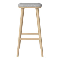 Light wood barstool with a soft gray upholstered seat. Minimalist, modern design with a clean finish.
