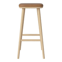 Light wooden bar stool with a tan leather seat, showcasing a simple, modern design.